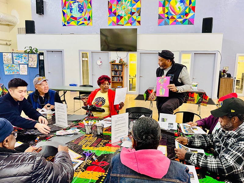 People around table working on art